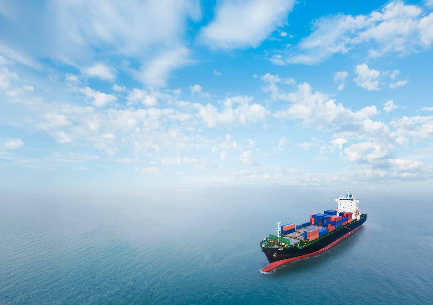A container ship sailing on open sea, viewed from above
